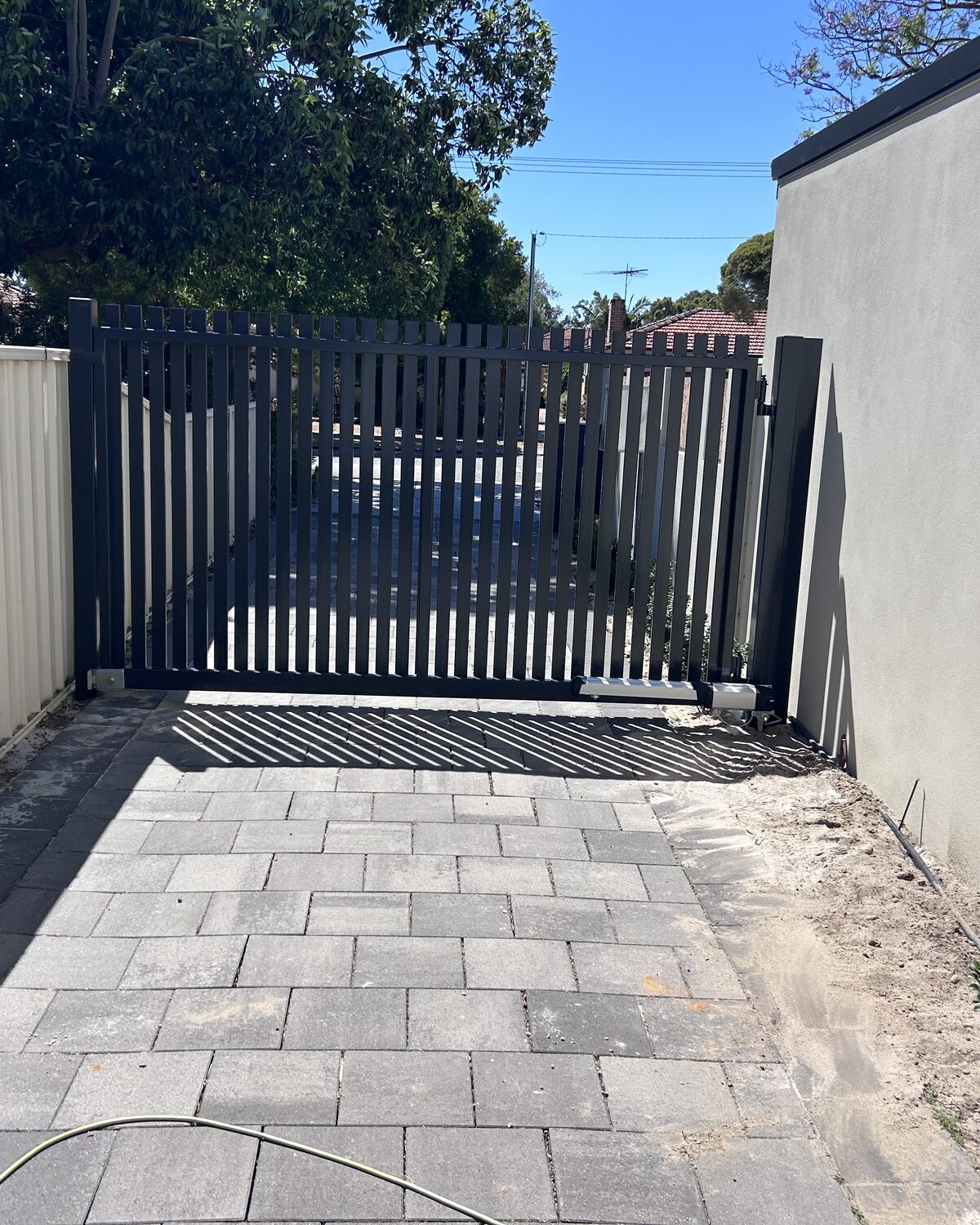 Dark slatted swing gate on a Subiaco driveway